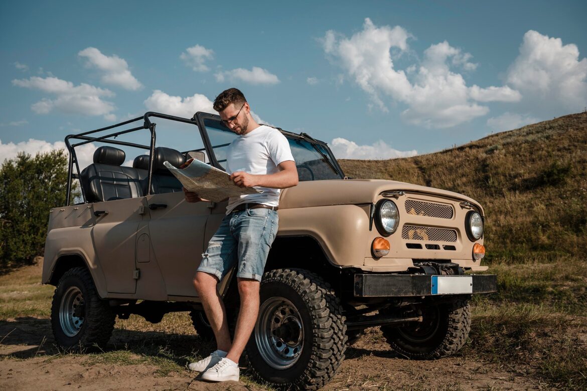 man-traveling-by-car-looking-map